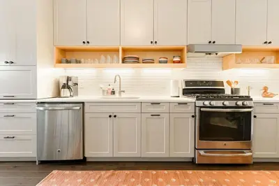 a kitchen with white cabinets and a stove top oven at Lux Washington-Park Rooftop Patio-Free Parking in Cincinnati