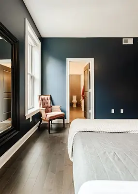 a bedroom with a bed and a chair and a window at Lux Washington-Park Rooftop Patio-Free Parking in Cincinnati