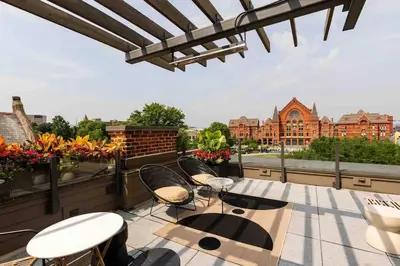 a patio with tables and chairs on a roof at Lux Washington-Park Rooftop Patio-Free Parking in Cincinnati