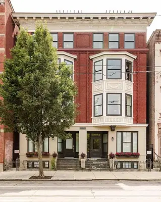 a red brick building with a tree in front of it at Lux Washington-Park Rooftop Patio-Free Parking in Cincinnati