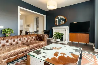a living room with a leather couch and a television at Lux Washington-Park Rooftop Patio-Free Parking in Cincinnati