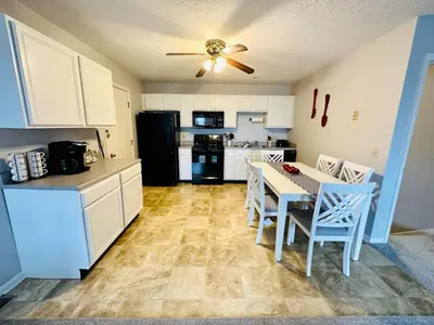 a kitchen with a table and chairs and a black refrigerator at Overbrook Delight -tranquil stay for day and night in Monroe