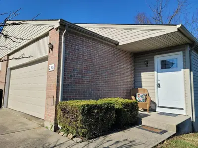 a brick house with a white door and a chair at Overbrook Delight -tranquil stay for day and night in Monroe