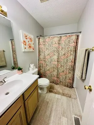 a bathroom with a toilet and a shower curtain at Overbrook Delight -tranquil stay for day and night in Monroe