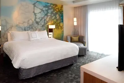 a hotel room with a bed and a chair at Courtyard by Marriott Youngstown Canfield in Canfield