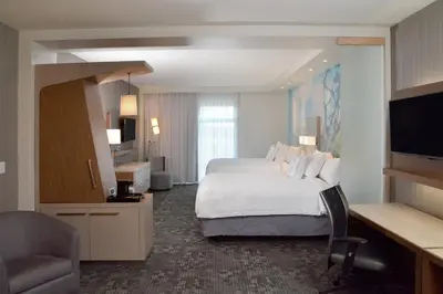 a hotel room with a bed and a television at Courtyard by Marriott Youngstown Canfield in Canfield