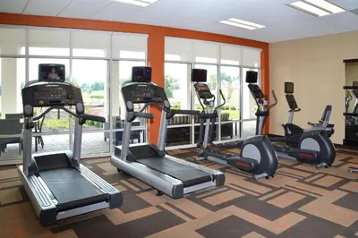 a gym with treadmills and ellipticals in a room at Courtyard by Marriott Youngstown Canfield in Canfield