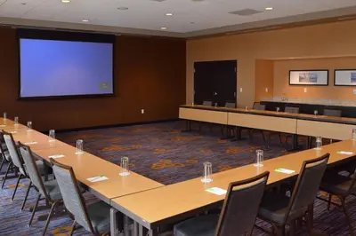 a conference room with tables and a projection screen at Courtyard by Marriott Youngstown Canfield in Canfield