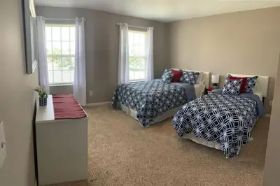 a bedroom with two beds and a couch and windows at 4 Bed 2.5 Bath Sleeps 10- King of Karincrest in Middletown