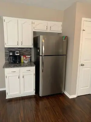 a kitchen with a stainless steel refrigerator and white cabinets at 4 Bed 2.5 Bath Sleeps 10- King of Karincrest in Middletown