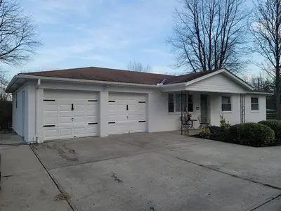 a small white house with two garage doors at Hot tub bubbles on Butler in Mason