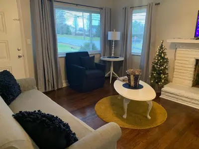 a living room with a couch and a christmas tree at Lovely Retreat Backyard With Deck and entertain room in Mason