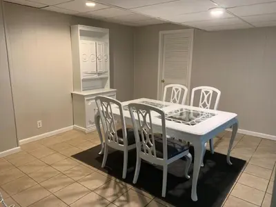 a dining room with a white table and chairs at Lovely Retreat Backyard With Deck and entertain room in Mason
