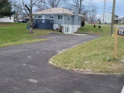 a driveway with a sign in front of a house at Lovely Retreat Backyard With Deck and entertain room in Mason