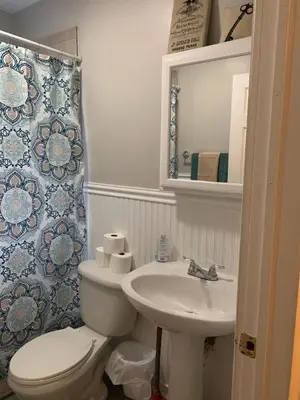 a white bathroom with a toilet and a sink at Lovely Retreat Backyard With Deck and entertain room in Mason