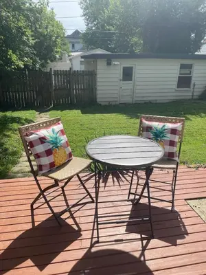 a patio table and two chairs on a deck at Main Street Oasis Pool and Hot Tub Sleeps 8 in Hamilton