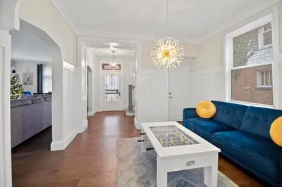 a living room with a blue couch and a table at Main Street Oasis Pool and Hot Tub Sleeps 8 in Hamilton