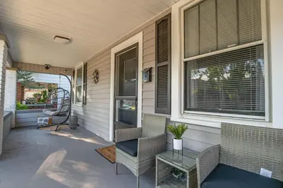 a porch with chairs and a table on a house at Dayton Street Sports Haven - 3 Bed 2 Bath Sleeps 8 in Hamilton