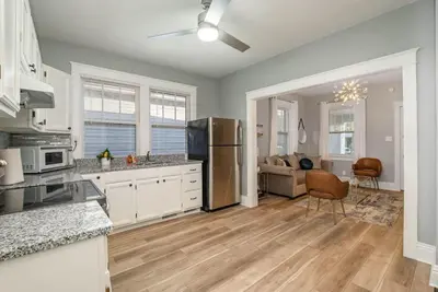a kitchen with a refrigerator and a living room at Dayton Street Sports Haven - 3 Bed 2 Bath Sleeps 8 in Hamilton