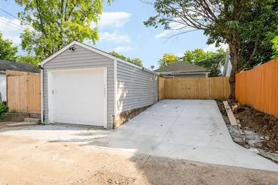 a garage in front of a wooden fence at Dayton Street Sports Haven - 3 Bed 2 Bath Sleeps 8 in Hamilton