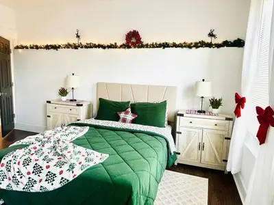 a bedroom with a green bed and two night stands at Holly Jolly Historic Home Where Its Always XMAS in Hamilton
