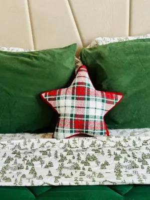 a christmas star on a bed with green pillows at Holly Jolly Historic Home Where Its Always XMAS in Hamilton