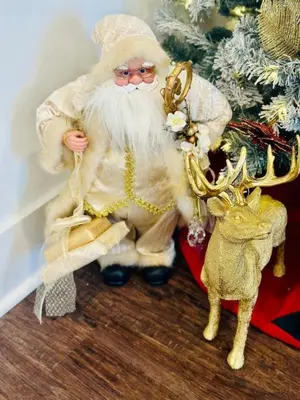 a santa claus figurine next to a christmas tree at Holly Jolly Historic Home Where Its Always XMAS in Hamilton