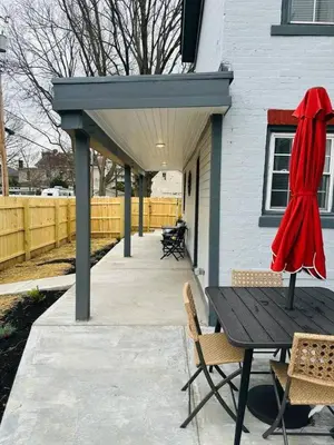 a patio with a table and chairs and a fence at Holly Jolly Historic Home Where Its Always XMAS in Hamilton