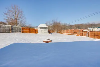 a yard covered in snow with a fence and a fence at Hocking Hills Hideaway Near Lake Logan in Logan
