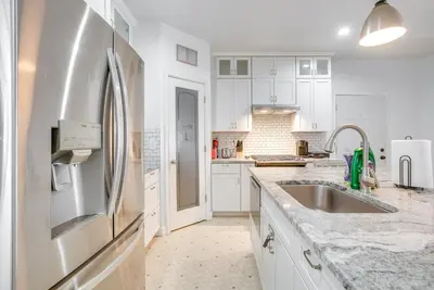 a kitchen with white cabinets and a stainless steel refrigerator at 4 Mi to Lake Logan Hocking Hills Apartment in Logan