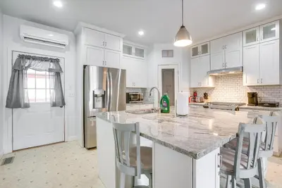 a kitchen with white cabinets and a granite counter top at 4 Mi to Lake Logan Hocking Hills Apartment in Logan
