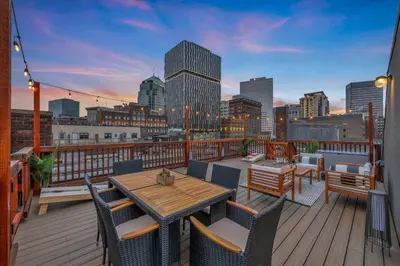 a balcony with a table and chairs and a city skyline at Penthouse Lofts on E 4th, Private Rooftop Patio in Cleveland