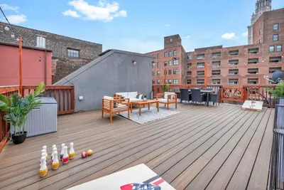 a deck with a table and chairs on a building at Penthouse Lofts on E 4th, Private Rooftop Patio in Cleveland