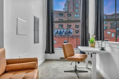 a office with a desk and a chair and a window at Penthouse Lofts on E 4th, Private Rooftop Patio in Cleveland