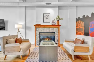 a living room with two couches and a fireplace at Lofts on E 4th, WALK TO CAVS, Sleeps 6 in Cleveland
