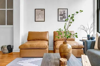 a living room with a couch and a vase on a table at Lofts on E 4th, WALK TO CAVS, Sleeps 6 in Cleveland