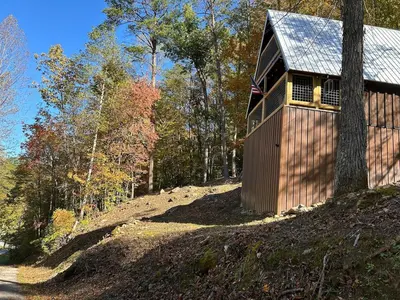 a house on top of a hill in the woods at Cherokee Cabin-Cave Run Lake and Cliff Views-Red River Gorge in Big Woods