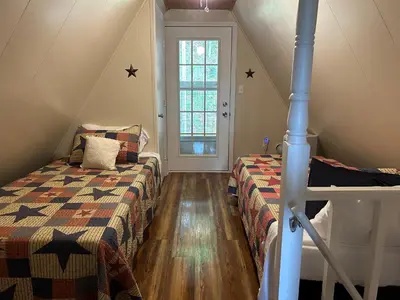 a attic bedroom with two beds and a window at Cherokee Cabin-Cave Run Lake and Cliff Views-Red River Gorge in Big Woods