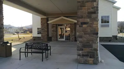 a porch with a bench in front of a building at Cobblestone Inn & Suites - Ambridge in Ambridge