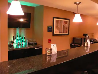 a bar in a restaurant with bottles on the wall at Cobblestone Inn & Suites - Ambridge in Ambridge