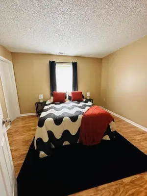 a bedroom with a black and white bed with a window at Tranquility in Trenton -Sleeps 9 in Trenton