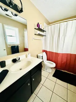 a bathroom with a sink and a toilet and a mirror at Tranquility in Trenton -Sleeps 9 in Trenton