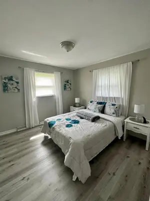 a bedroom with a large bed and two windows at 2 Homes for large group Hot Tub in Mason