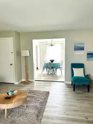 a living room with a table and a blue chair at 2 Homes for large group Hot Tub in Mason