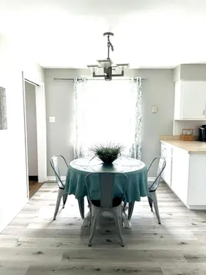 a dining room table with a green tablecloth and chairs at 2 Homes for large group Hot Tub in Mason