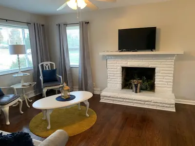 a living room with a fireplace with a flat screen tv at 2 Homes for large group Hot Tub in Mason
