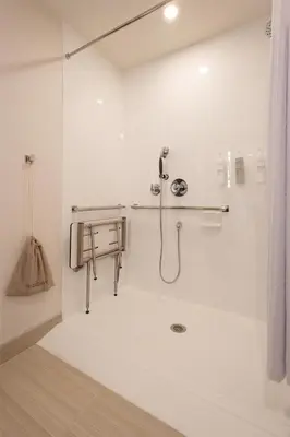 a white bathroom with a shower and a sink at Hilton Garden Inn Dayton Downtown in Dayton