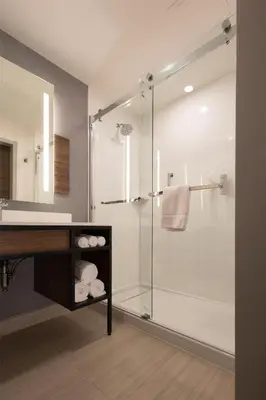 a bathroom with a glass shower and a sink at Hilton Garden Inn Dayton Downtown in Dayton
