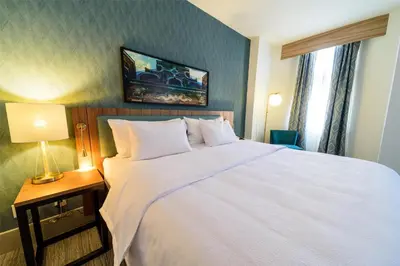 a bedroom with a large white bed and a lamp at Hilton Garden Inn Dayton Downtown in Dayton