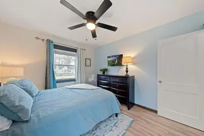 a bedroom with a blue bed and a ceiling fan at Welcome to the Treasure house! in Westlake